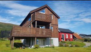 een huis met een houten dak en een rood huis bij Strand Apartments in Kvaloysletta