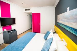 a bedroom with a large bed with a red door at Mera Park Hotel in Antalya