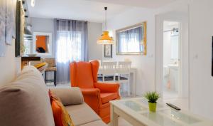 a living room with a couch and an orange chair at Mezquita Apart. with Free Parking in Córdoba