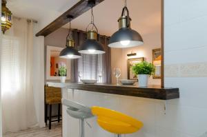 a kitchen with a counter and a yellow chair at Mezquita Apart. with Free Parking in Córdoba