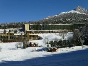 um hotel na neve em frente a uma montanha em STUDIO CHALEUREUX aux pieds des pistes de ski des Glovettes em Villard-de-Lans
