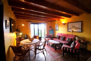 a living room with a red couch and a table at Casita Roco 3 in La Asomada