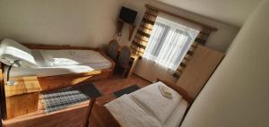 um pequeno quarto com uma cama e uma janela em Gasthof Kasperle em Spittal an der Drau