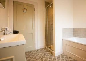 a bathroom with a shower and a sink and a tub at Church Lane Holiday Home, Warrenpoint in Warrenpoint +23 photos