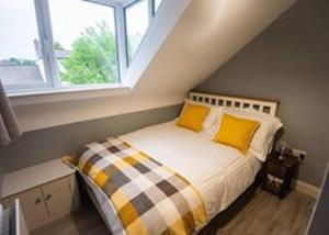 a bedroom with a bed with yellow pillows and a window at Church Lane Holiday Home, Warrenpoint in Warrenpoint