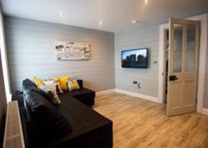 a living room with a couch and a television at Church Lane Holiday Home, Warrenpoint in Warrenpoint