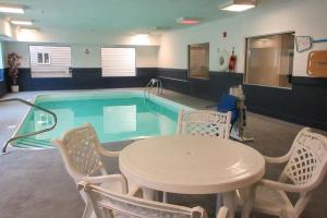 a swimming pool with a table and chairs and a table and a table at Quality Inn in Sawyer