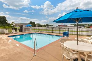 - Piscina con mesa y sombrilla en Quality Inn Monteagle TN en Monteagle