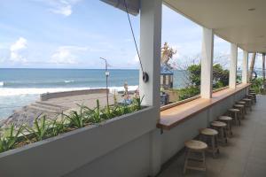 een balkon met krukken en uitzicht op de oceaan bij Sau Bali Beach House Canggu in Canggu