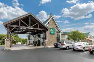 Quality Inn Monteagle TN في مونتيغل: مبنى فيه سيارات متوقفة في موقف للسيارات