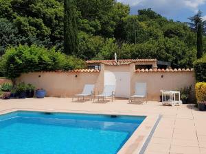 a swimming pool with two chairs and a house at Luxurious holiday home with private pool in Salernes