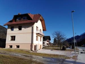 a white building with a red roof on a street at Apartma Viktorija in Kranjska Gora