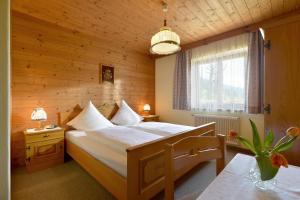 una camera con un grande letto in una parete di legno di Bauernhof Strasserhof a Söll