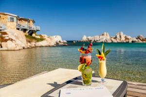 two cocktails sitting on a table next to the water at Hotel & SPA des Pecheurs in Bonifacio