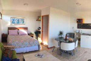 纳维达德Cabañas Suite Matanzas的一间带床、桌子的卧室和一间厨房