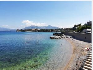 a beach with people swimming in the water at Casa Olivella in Santa Flavia