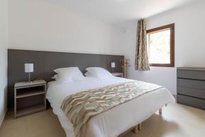 sypialnia z dużym białym łóżkiem i oknem w obiekcie Domaine A Marella w mieście LʼÎle-Rousse