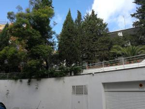 eine weiße Garage mit Bäumen oben drauf in der Unterkunft Casa Vilaró Park Guell in Barcelona