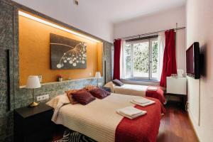 Habitación de hotel con 2 camas y ventana en Casa Vilaró Park Guell en Barcelona