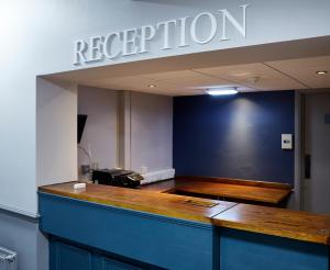 a reception desk in a room with a sign on the wall at Ravensworth Arms by Chef & Brewer Collection in Gateshead