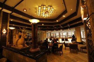 a lobby of a restaurant with people sitting at tables at Windhoek Country Club Resort in Windhoek