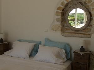 a bedroom with a bed with a window on the wall at Villa Petradi (150 meters from the sea) in Ambelas