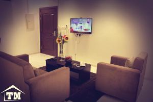 a living room with couches and a flat screen tv at شقق الزوايا الهادئه للشقق المخدومة - اقتصادي - Alzwaya Alahadea Apartments in Jeddah