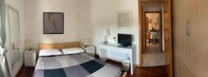 Dormitorio pequeño con cama y TV en Malpensa Home Rent, en Gallarate