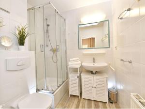 La salle de bains est pourvue d'une douche, de toilettes et d'un lavabo. dans l'établissement Wohnpark Stadt Hamburg in Binz - WG 25, à Binz