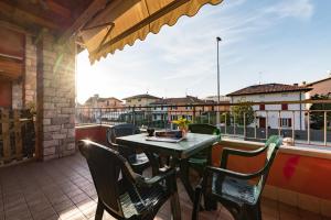 un patio con tavolo e sedie sul balcone. di Gardappartamenti Artisti Pool a Desenzano del Garda