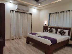 a bedroom with a large bed in a room at Hotel Grand Ganesha in Ganpatipule