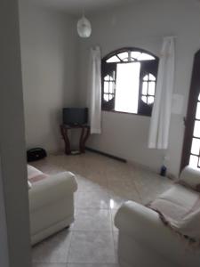 sala de estar con sofá y 2 ventanas en Casa em São Pedro da Aldeia - RJ en São Pedro da Aldeia