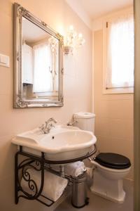 uma casa de banho com um lavatório, um WC e um espelho. em Grimaldi Apartments Ca Del Moro em Veneza