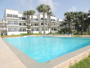 a large swimming pool in front of a building at WATERFRONT FLAT 4 BEDROOM in Kololi