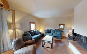 uma sala de estar com sofás azuis e uma mesa em Madulaina 6B em St. Moritz