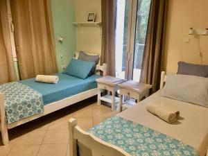 a room with two beds and a table and a window at Apartment near airport and beach in Artemida