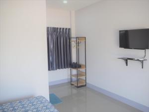 um quarto com uma televisão e uma cama num quarto em Maharak Resort em Nong Khai