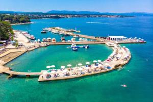 a group of people on a pier with umbrellas in the water at Apartment Jadranka in Malinska