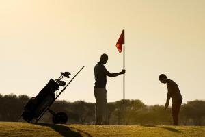 un grupo de tres hombres con una bandera y un cochecito en Windhoek Country Club Resort, en Windhoek