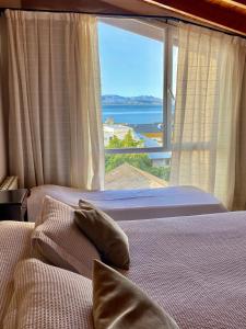 a bedroom with a large window with a view of the ocean at 460 LOFT Apartments in San Carlos de Bariloche