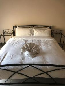 a white bed with a hat on top of it at Aphrodite Sands Resort - The Penthouse in Mandria +27 photos