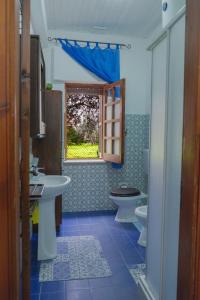 a bathroom with two sinks and a toilet and a window at Il Fenicottero Guest House in Campofelice di Roccella