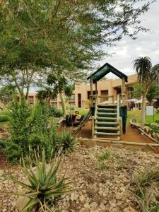 un parque infantil en el patio de una casa en Windhoek Country Club Resort, en Windhoek
