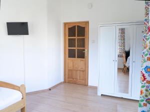 Habitación con puerta de madera y suelo de madera. en Willa Ślimakówka en Zakopane