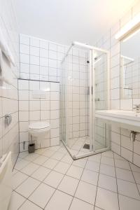 a bathroom with a shower and a toilet and a sink at Thon Partner Hotel Narvik in Narvik