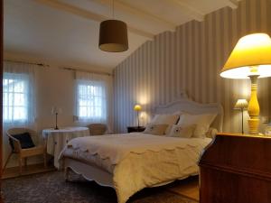 a bedroom with a large white bed and two tables at Chambres d'Hôtes Le Clos Du Verger in Cattenom