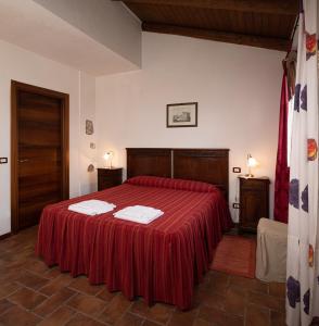 ラ・モッラにあるCasa Del Pozzoのベッドルーム1室(赤いベッド1台、タオル2枚付)