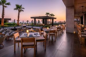 a restaurant with tables and chairs with the sunset in the background at Amara - Sea Your Only View™ in Limassol