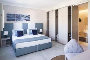 a bedroom with a king sized bed and a chair at VOI Marsa Siclà Essentia in Sampieri