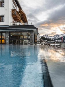 a hotel swimming pool with mountains in the background at Wellnesshotel Cervosa in Serfaus